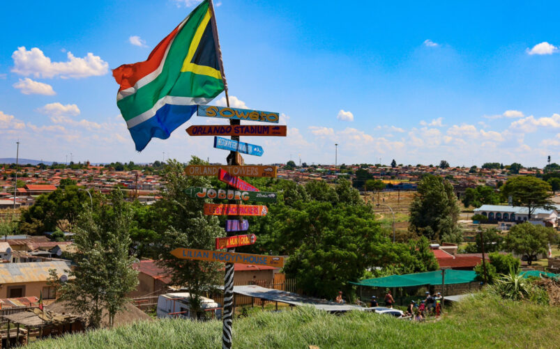 Panneau coloré à Soweto sous le drapeau sud-africain, symbole de culture et de mémoire historique, lors d’un voyage Karavaniers