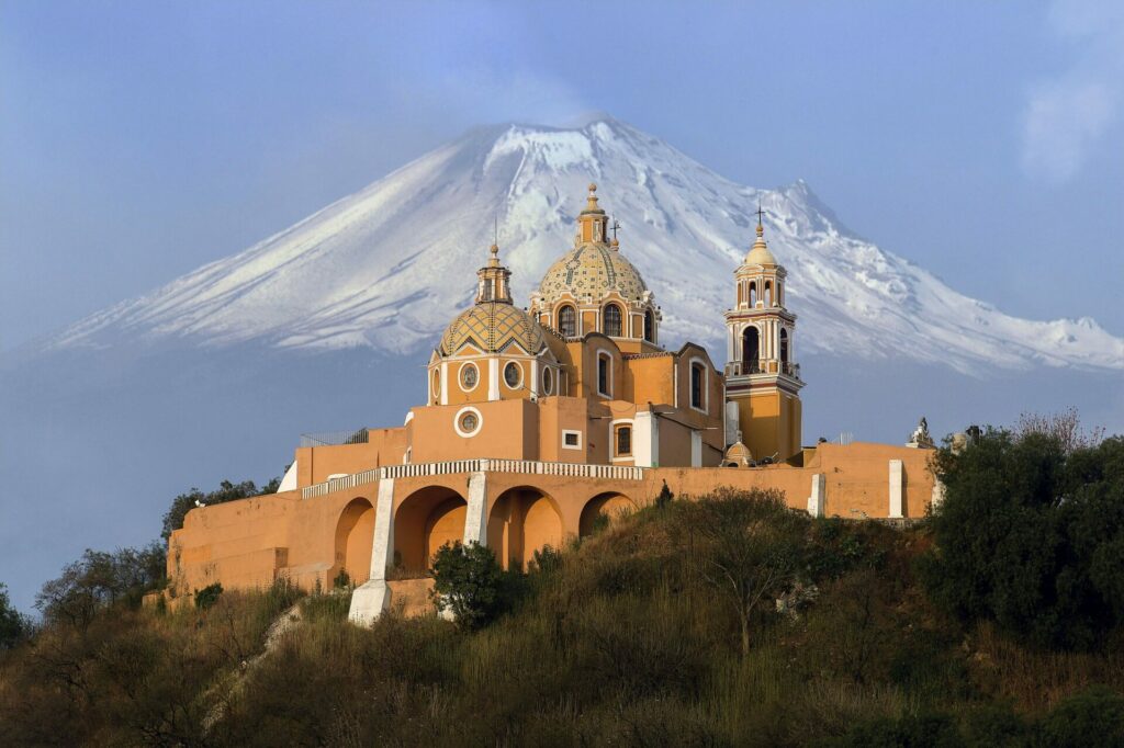 Église baroque de Cholula avec le volcan Popocatépetl en arrière-plan.
