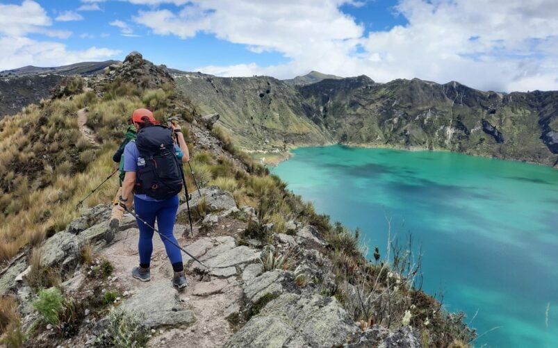 Randonneur au bord du cratère de Quilotoa avec vue sur le lac turquoise en Équateur