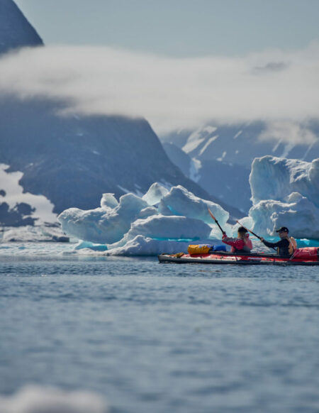 Kayakistes pagayant parmi les icebergs du Groenland lors d'une aventure à la pagaie.
