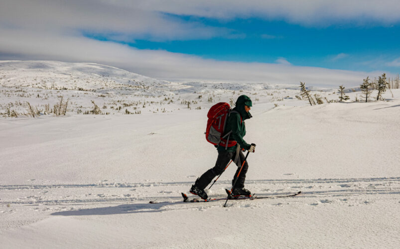 Skieur solitaire progressant sur les plateaux enneigés du massif Uapishka