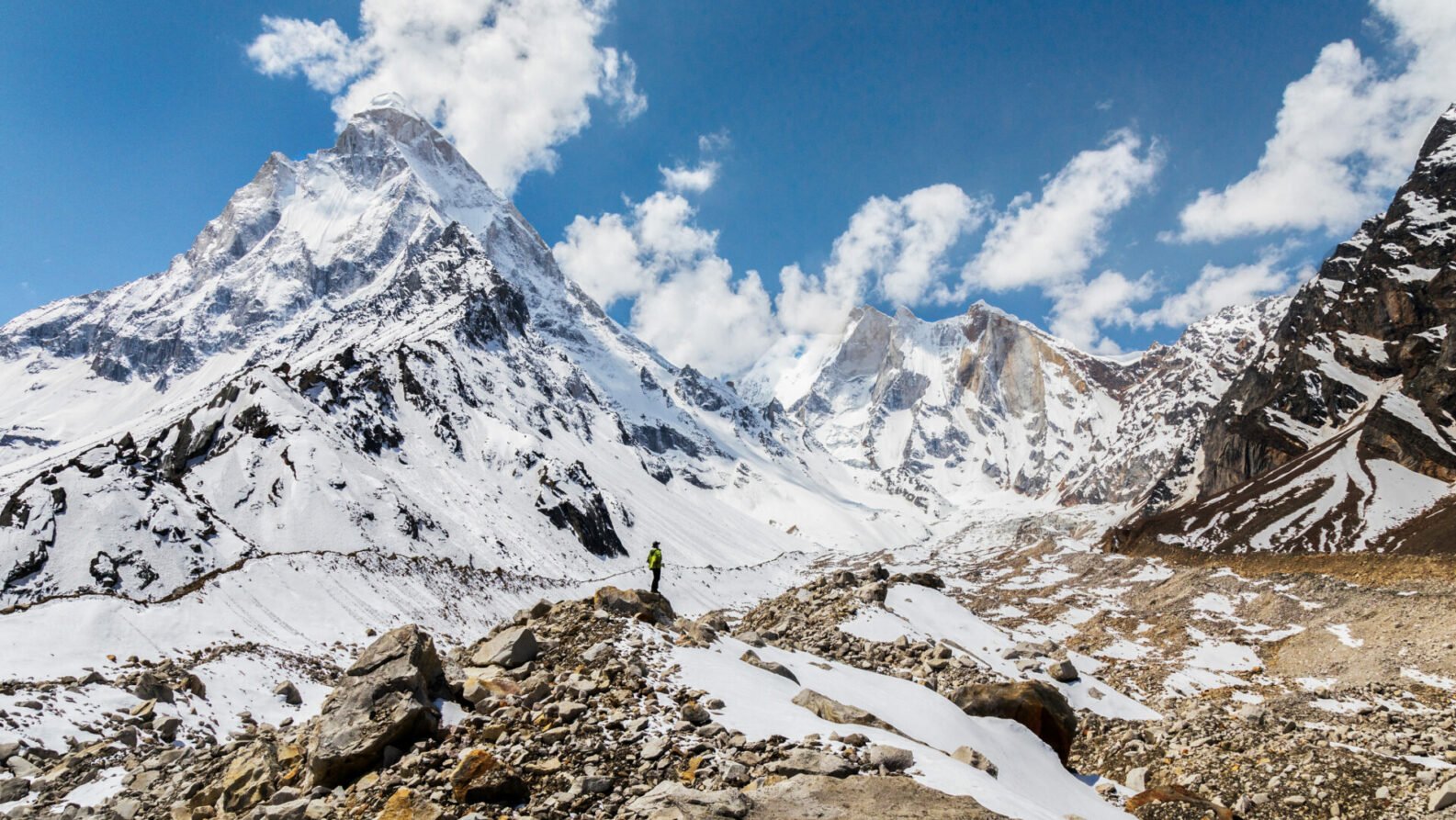 Vue plongeante sur une vallée encaissée, encerclée de hauts sommets enneigés