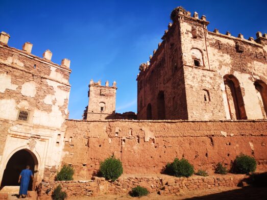 Kasbah traditionnelle en pisé, aux teintes chaudes, sous un ciel bleu éclatant