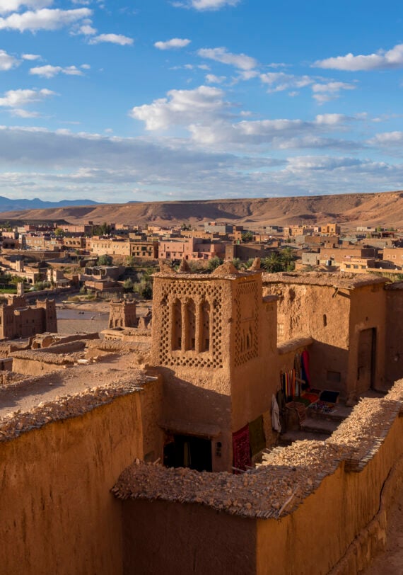 Kasbah traditionnelle en terre ocre dominant la vallée, architecture typique du sud marocain