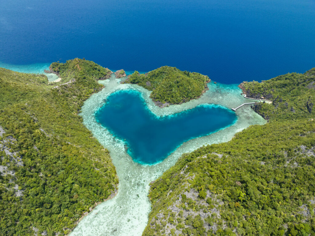Archipel corallien aux eaux turquoise vu du ciel, en forme de cœur