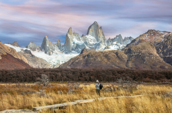 Voyageur seul contemplant le massif du Fitz Roy et ses sommets enneigés au lever du soleil, Patagonie argentine.