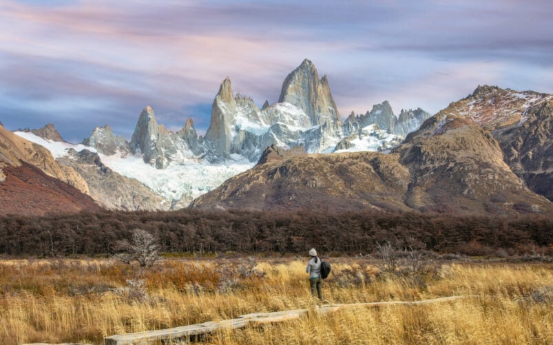 Voyageur seul contemplant le massif du Fitz Roy et ses sommets enneigés au lever du soleil, Patagonie argentine.