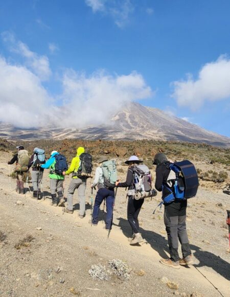 Marche en altitude sur un sentier minéral, sous un ciel clair.