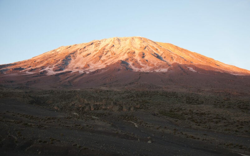Sommet du mont Kilimandjaro au lever du soleil avec lumière dorée sur les pentes