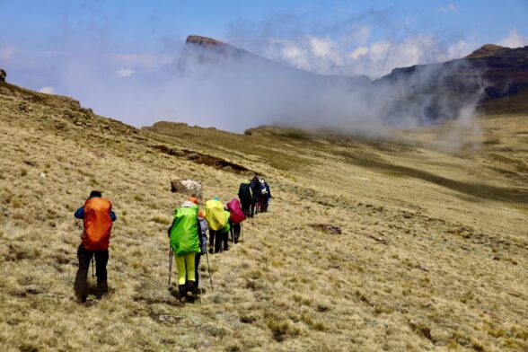Randonneurs progressant dans les montagnes embrumées du Lesotho avec un groupe de voyageurs.