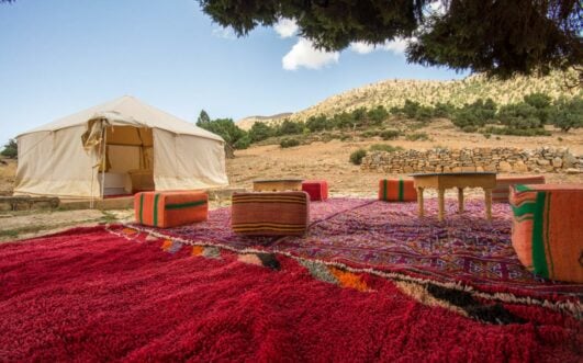 Campement berbère traditionnel dressé sur un tapis de couleurs vives