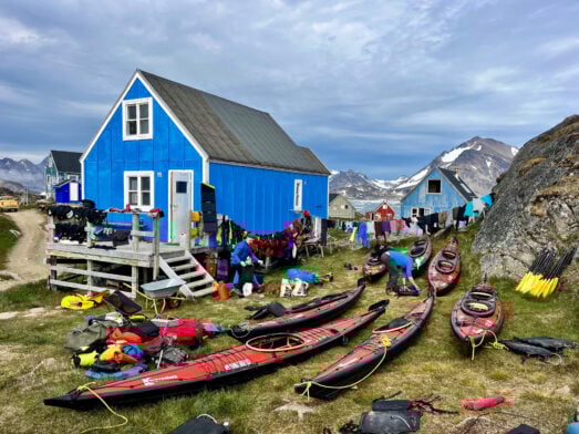 Maisons colorées près du rivage, campement de kayaks sur l’herbe