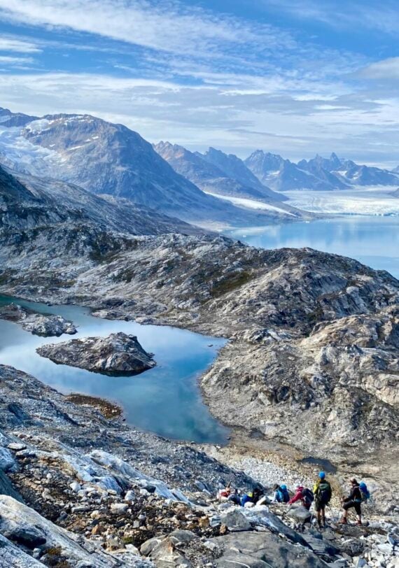 Randonneurs progressant entre lacs d’altitude et crêtes rocheuses dans un paysage arctique