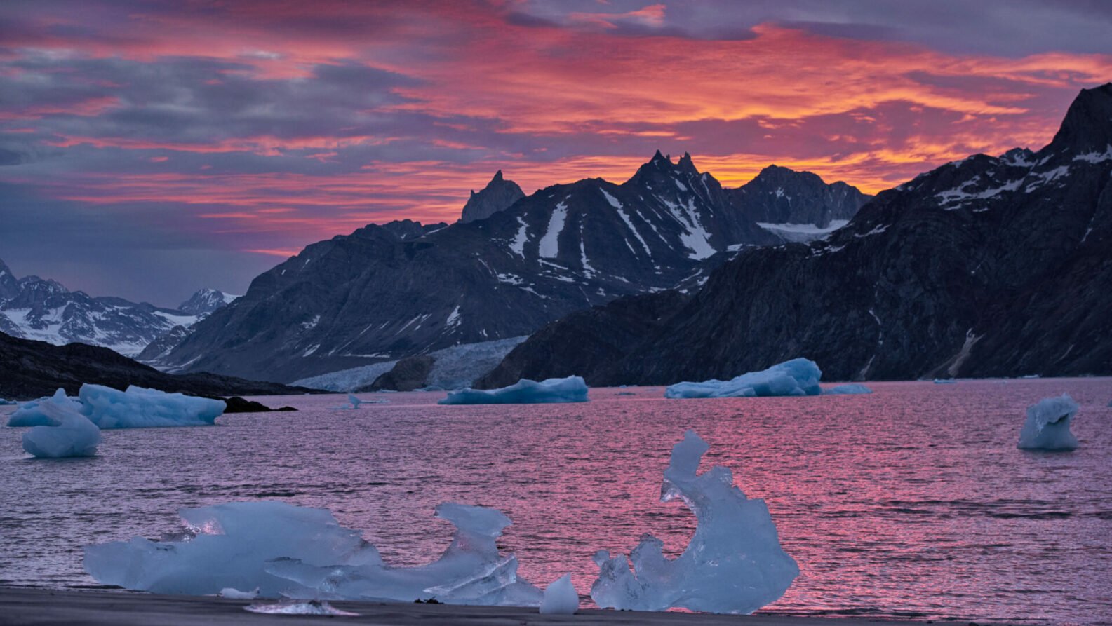 Lumière rose sur les glaces flottantes à marée basse, ciel enflammé au crépuscule arctique