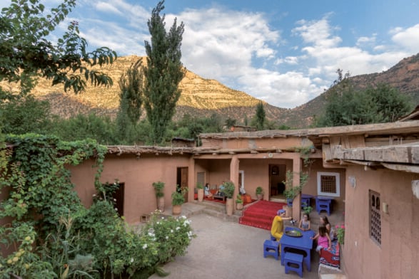 Maison traditionnelle aux murs ocres avec mobilier coloré, dans un village berbère
