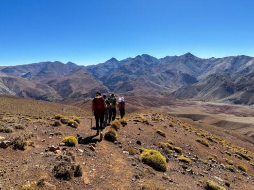 Groupe de randonneurs dans les montagnes arides de l’Atlas au Maroc, trek d’aventure avec Karavaniers