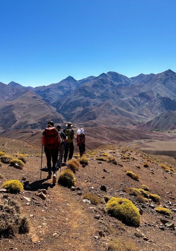 Groupe de randonneurs dans les montagnes arides de l’Atlas au Maroc, trek d’aventure avec Karavaniers