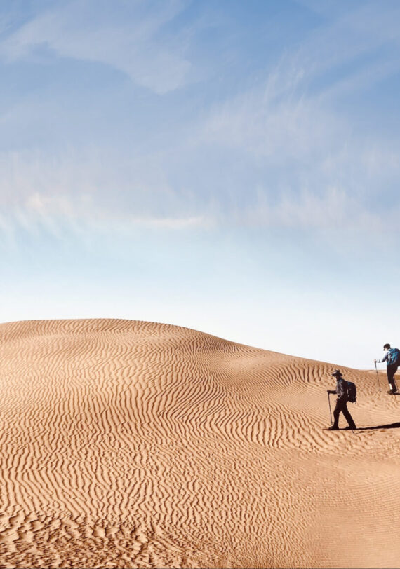 Marcheurs sur les dunes ondulantes du désert marocain, sous un ciel limpide
