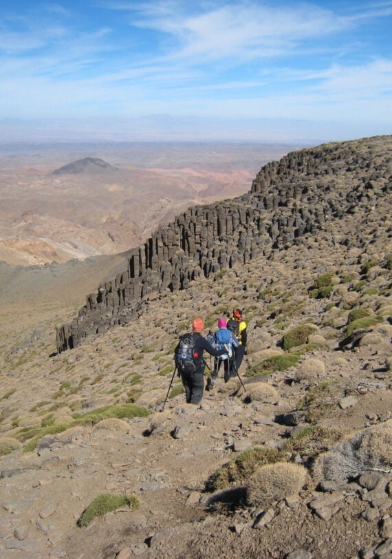 Randonneurs marchant sur les crêtes volcaniques arides du Siroua, vue dégagée sur les plateaux