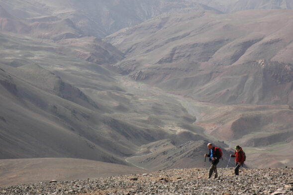 Randonneurs progressant dans un paysage montagneux aride du Haut Atla