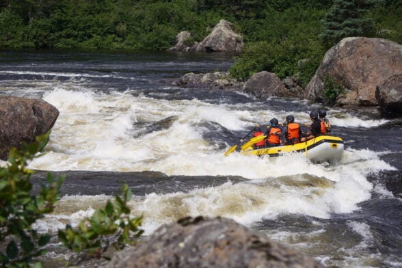 Groupe en kayak dans des rapides blancs.