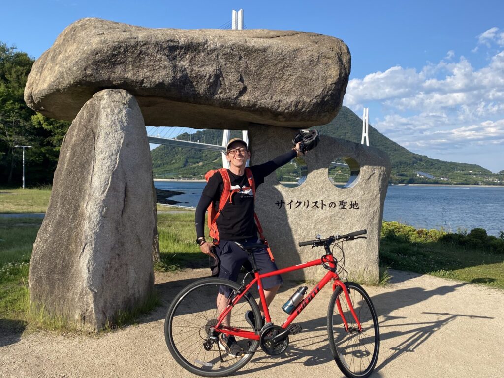 Cycliste devant un ancien mégalithe à inscription japonaise