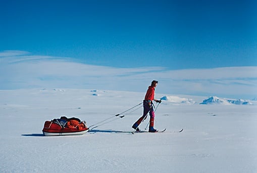 Skieur tirant un traîneau sur une plaine glacée