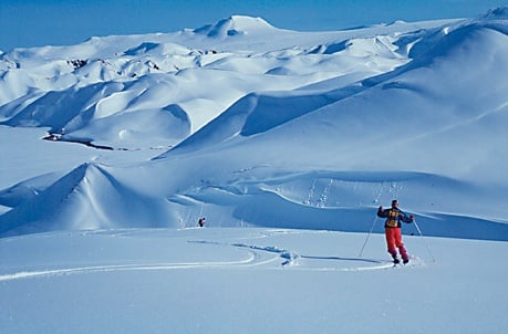 Skieur en progression dans un vaste paysage de neige et de dunes glacées