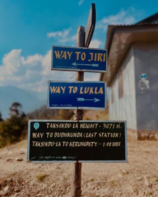 Panneau de randonnée à Taksindu-La au Népal, indiquant les directions vers Jiri, Lukla et Dudhkundha, sur un itinéraire de trek d’altitude avec Karavaniers