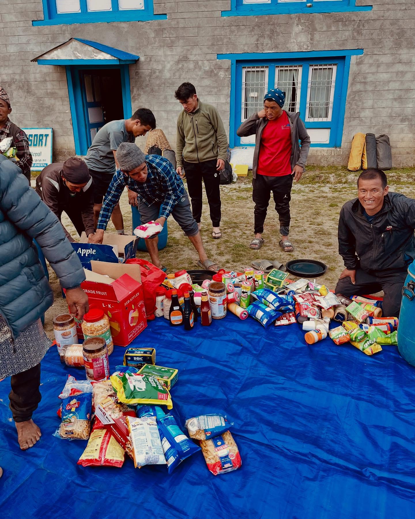Lors d'une étape en Pays Sherpa, les randonneurs et les sherpas répartissent la nourriture dans les sacs afin d'avoir des provisions pour l'expédition.