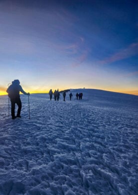 Trek au Kilimandjaro avec Karavaniers, marche des voyageurs sur les neiges éternelles au lever du soleil