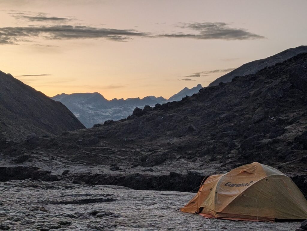 Une tente plantée dans une zone rocheuse offre un abri aux randonneurs qui explorent les paysages sauvages de la Cordillère Royale. - Karavaniers